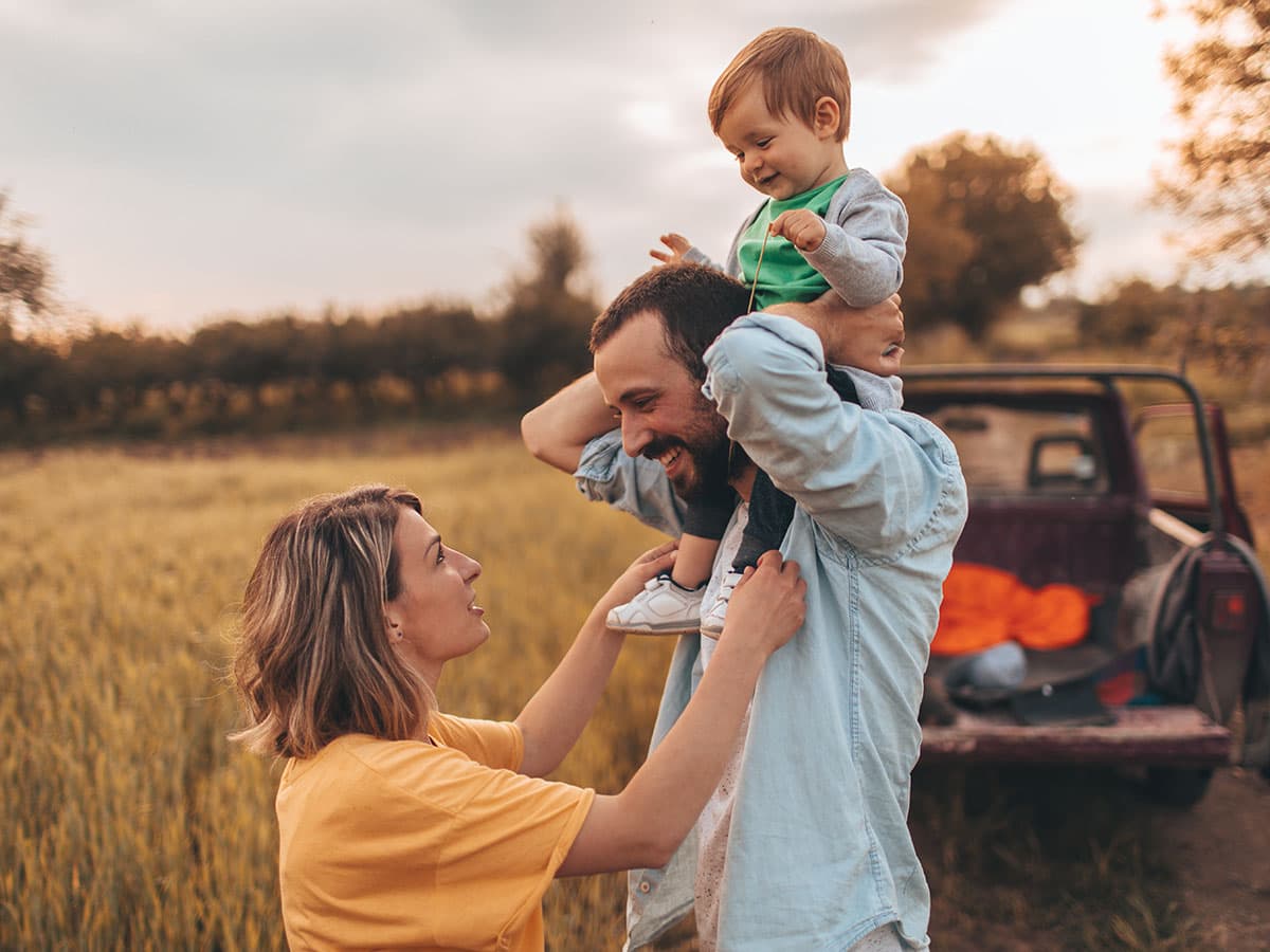 En kvinde sidder ved et bord og fokuserer på sin telefon, med en neutral baggrund og blød belysning