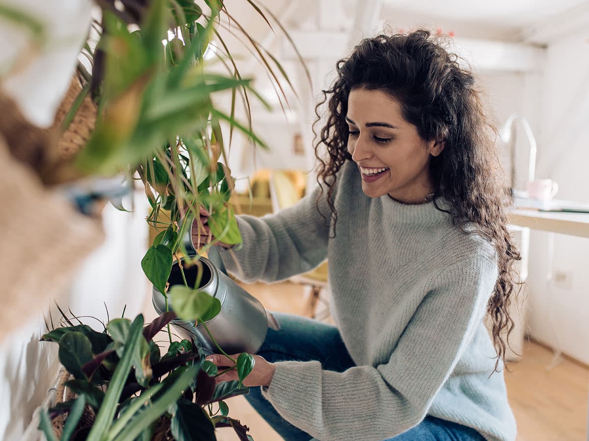 En mand smiler, mens han holder en mobiltelefon i hånden, og ser glad og engageret ud